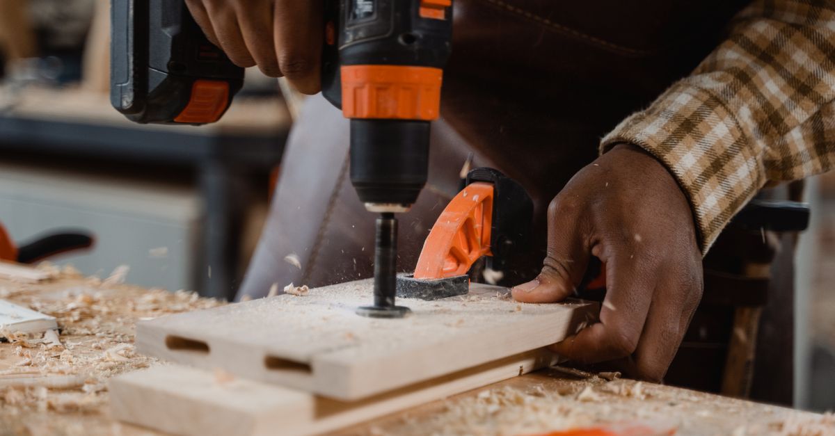 Skilled carpentry work with power tools on a wooden plank
